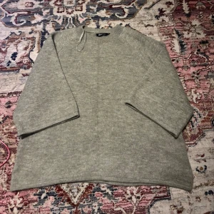 Grön stickad tröja från Gina Tricot - Mysig grå stickad tröja från Gina Tricot i storlek S. Tröjan har en enkel och avslappnad passform med rund halsringning och långa ärmar!!