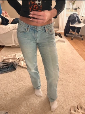 Ljusblå raka jeans med hög midja - Säljer ett par ljusblå jeans med rak passform och hög midja. Jeansen har klassiska fem fickor och är tillverkade i denim med en snygg tvätt. Perfekta för en avslappnad och trendig look. Storlek w26 l 32