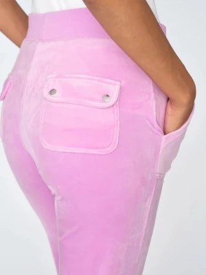 Rosa Juicy couture  - Säljer ett par ljusrosa mjukisbyxor i velour med raka ben och bred resår i midjan. Byxorna har praktiska fickor fram och bak, varav bakfickorna har lock med silverfärgade knappar. Perfekta för en chill och trendig look.