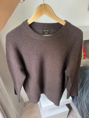 Brun stickad tröja från Massimo Dutti - Mysig brun stickad tröja från Massimo Dutti med rund halsringning och långa ärmar. Tröjan har en enkel och stilren design, perfekt för lager på lager och passar till det mesta. Materialet ser ut att vara mjukt och av hög kvalitet.