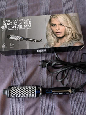 Värmeborste Björn Axén Magic Style Brush 38 mm - En elektrisk stylingborste från Björn Axén Tools, Magic Style Brush 38 mm. Borsten är svart med silverfärgad cylinder och har borst av plast. Perfekt för att skapa volym och glans i håret. Levereras med sladd och originalförpackning. Absolut nyskick, endast provad. Från OBH Nordica. Pris 450 kr.