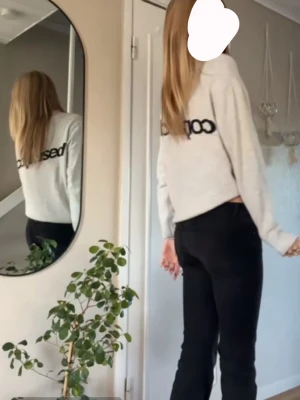 ljusgrågrå långärmad  - en ljusgrå finstickad tröja med text på ryggen. 