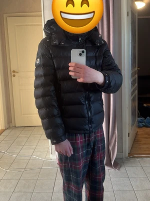 Bvaldi jacka - Säljer en svart pufferjacka från bvaldi med avtagbar huva och två dragkedjefickor framtill. Jackan har quiltad design och en logotyp på vänster ärm. Perfekt för kalla dagar och riktigt skön att bära. Nypris ca 3000kr används fåtal gånger