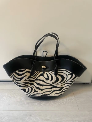 Hm zebra väska - Säljer denna jättepopulära och eftertraktade väskan då den inte kommer till användning🤍 väskan är stor och har plats med allt man behöver🤍 använd 1 gång och är därför i nyskick