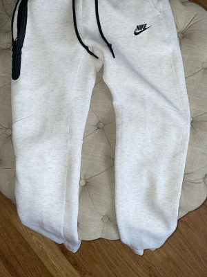Vita mjukisbyxor från Nike - Fina vita Nike tech byxor, finns en liten fläck som inte syns jätte mycket annars är allt annat bra. Pris kan diskuteras. Storlek S herr.