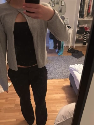 Ljusgrå cardigan med knapp - Säljer en ljusgrå cardigan med en knapp upptill och öppen framtill från bikbok