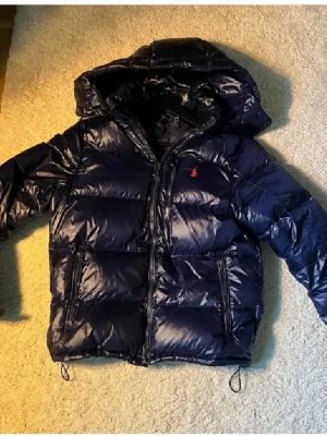 Mörkblå dunjacka från Polo Ralph Lauren - Snygg mörkblå dunjacka från polo Ralph louren passar mellan 165-180 8/10 i betyg  bara höra er vid frågor eller funderingar 