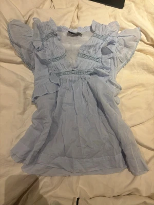 Blå volangblus  - Så söt ljusblå volangblus från neo noir!🫶🏻Står ej storlek men passar S/M😊