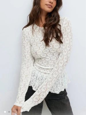 Vit spetsstickad peplumtröja - Helt ny med prislapp! Slut på hemsidan. Säljer en vit långärmad spetsblus med peplum och rund hals. Blusen har ett romantiskt mönster och är tillverkad i ett tunt, genomskinligt spetsmaterial som ger en feminin look. Perfekt att styla med jeans eller kjol. 