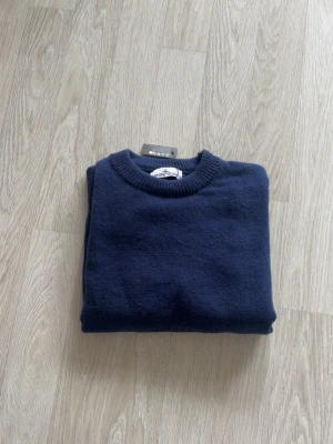 Mörkblå stickad tröja Stone Island - Mörkblå stickad tröja från Stone Island med klassisk rund halsringning och ribbade muddar. Tröjan har den ikoniska loggan på vänster ärm. Passar perfekt till dig som vill lägga till en extra tutch. Storlek S, Helt ny. Vid frågor eller funderingar tveka inte på att skriva mvh 😁