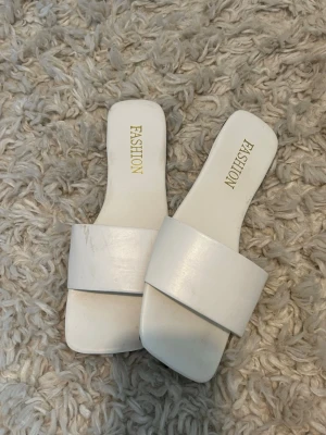 Sandaler - Stilrena vita slip-in sandaler från Fashion. Perfekta för att gå ner på stranden i sommar!