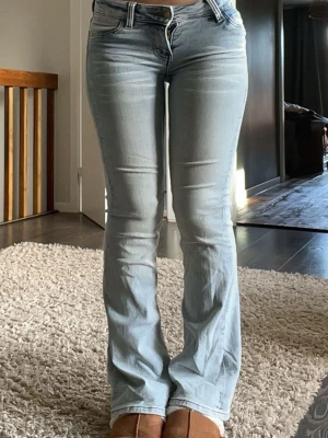Ljusblå bootcut jeans - Säljer ett par ljusblå bootcut jeans med klassisk femficksdesign och super  låg midja. 