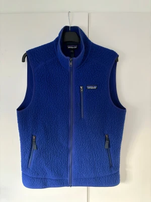 Patagonia väst herr M - Galet snygg helt ny Patagonia väst i storlek M säljes. Extremt trendig och grym passform. Perfekt nu till sommaren och våren och inga hål eller fläckar. Väldigt unik klarblå färg som passar till allt och får din look att poppa! Pris ej hugget i sten