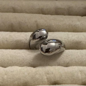 Chunky silverfärgad ring - Säljer en chunky och modern ring i silverfärgad med en mjukt böjd, organisk form. Perfekt statement-piece för dig som gillar stilrena accessoarer med lite edge.