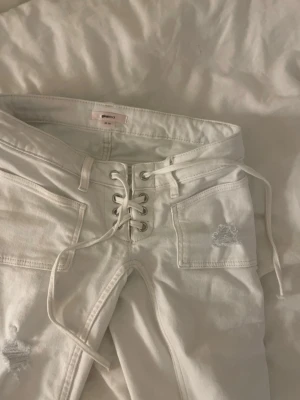 Vita snörade jeans från Gina Tricot - Säljer ett par vita jeans från Gina Tricot i storlek XS