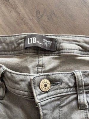 Grå jeans från LTB - Snygga grå jeans från LTB med klassisk femficksmodell och lätt utsvängda ben. Jeansen har en ljusgrå tvätt och metallknapp med LTB-logga. Perfekta för en avslappnad och trendig look.