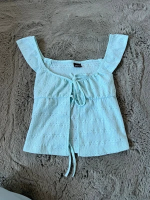 Blå topp! - Säljer en blå/ turkos sommar topp från Gina tricot i storlek S! Toppen är knappt använd och i väldigt bra skick!💗