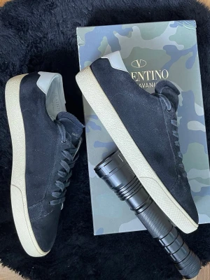 Saint Laurent skor  - Säljer ett par exklusiva Saint Laurent sneakers i svart mocka med stilren design och beige sula. Limited edition-modell som är svår att få tag på och passar perfekt till både casual och mer uppklädda outfits.  Skorna är i väldigt fint skick, sparsamt använda och väl omhändertagna – cirka 8/10 i skick med endast mindre tecken på användning.  • Storlek: 44 • Material: Mocka • Färg: Svart med beige sula • Skick: 8/10 • Tillbehör: Ingen originalbox medföljer  Riktigt clean och tidlös modell. 