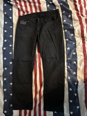 Svarta jeans med nitar från Amisu - Säljer ett par svarta jeans från amisu och coola silverfärgade nitar på myntfickan. Jeansen har klassisk femficksdesign och bälteshällor. 