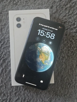 Svart iPhone 11 med originalkartong - Säljer en svart iPhone 11 från Apple. Mobilen har en stilren design med rundade hörn, glasbaksida och två kameror på baksidan. Skärmen är stor och har en modern look. Levereras med originalkartong. Skickar nollställd 
