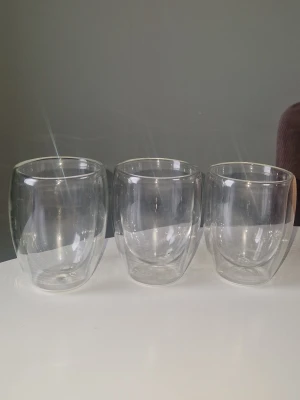 Dubbelväggiga glas - Säljer tre genomskinliga dubbelväggiga glas i rund form. Perfekta för både varma och kalla drycker tack vare isoleringen. Glasen är stilrena och moderna, tillverkade i klart glas utan synligt märke. Rymmer 400ml