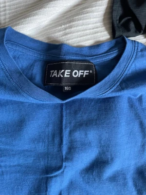 Blå t-shirt från Take Off - En enkel blå t-shirt från Take Off med rund hals och korta ärmar. Tillverkad i mjuk bomull som känns skön mot huden. Perfekt till jeans eller shorts för en avslappnad look.