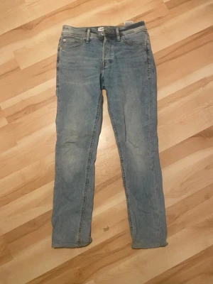 Slim fit jeans från Jack & Jones - Snygga ljusblå slim fit jeans från Jack & Jones, modell Glenn. Klassisk femficksdesign och dragkedjegylf. Jeansen har en smal passform och är tillverkade i mjukt denimtyg som ger en avslappnad look.