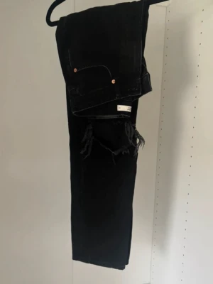 Svarta raka jeans med hål - I fint skick och i en lite urtvättad svart färg.