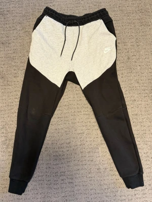 Nike mjukisbyxor svart/grå - Nike mjukisbyxor i svart och ljusgrått, har använt några gånger, små hål inget man ser på långt håll, det står storlek M men den passar som small, säljer för väldigt billigt, kan diskutera priset.
