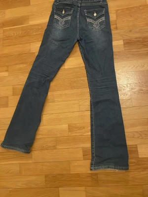 Blå bootcut jeans med broderade fickor y2k vintage cute - Bootcut jeans med snygga fickor. Väldigt stretchiga och bekväma jeans. Har ingen lapp i sig men skulle säga xs-s. Endast använts få gånger och är i bra skick.
