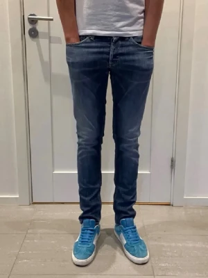 Dondup George jeans - Säljer ett par mörkblå slim fit jeans ifrån Dondup med snygg tvätt och klassiska fem fickor. Jeansen har normal midja och smal passform hela vägen ner. Perfekta för dig som gillar en modern och stilren look.