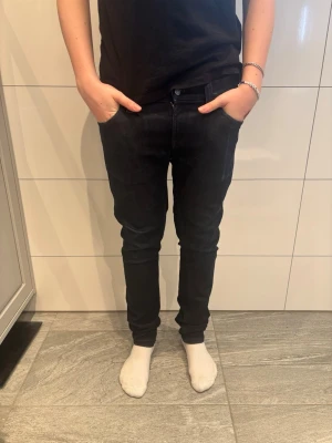 Nudie jeans  - Snygga mörkblå slim fit jeans från nudie med klassisk femficksdesign och normal midja. Jeansen har en smal passform hela vägen ner och är tillverkade i ett stretchigt denimtyg för extra komfort. Perfekta för en trendig och avslappnad stil.