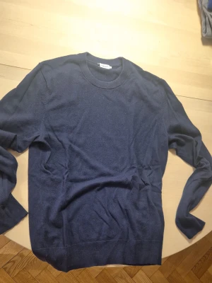 Mörkblå stickad tröja från Filippa K - Snygg mörkblå stickad tröja från Filippa Kmed rund halsringning och långa ärmar. 