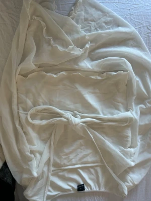 Vit offshoulder blus med knytband - Säljer en vit offshoulder blus från shein i tunn, luftig och mjuk kvalitet. Blusen har volangkant upptill och ett brett knytband i midjan för en snygg siluett. Perfekt för dig som gillar en romantisk och trendig stil.