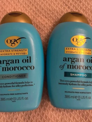 OGX Argan Oil of Morocco duo - Säljer ett set med OGX Extra Strength Argan Oil of Morocco shampoo och balsam, båda i blå plastflaskor på 385 ml. Perfekt för dig som vill ha återfuktat och silkeslent hår. Sulfatfria och med vårdande arganolja för extra glans.