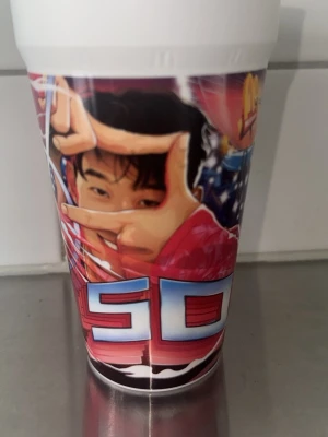 Plastmugg med Son -tryck - Cool plastmugg med färgglatt Fotbolspelare från Vm -inspirerat motiv och stora bokstäver i rött och blått. Muggen har detaljer av en tiger och figurer i actionposer. Perfekt för dryck eller som samlarpryl för fans av tecknade Vm fotboll.