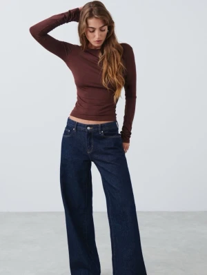 Brun långärmad topp med öppen rygg - Snygg brun långärmad topp med tight passform och öppen rygg. Toppen är croppad och har en enkel, stilren design som passar perfekt till jeans eller kjol. Tillverkad i mjukt och stretchigt material för en bekväm känsla.