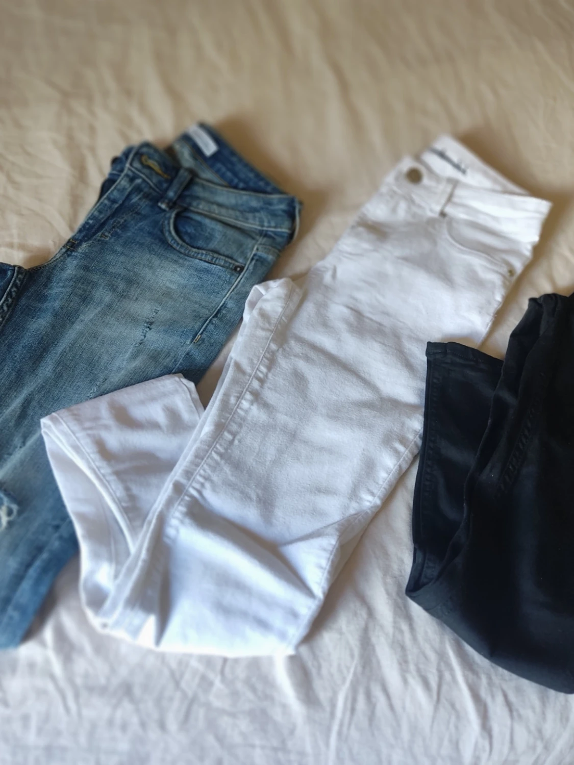 Tre par jeans i olika färger
