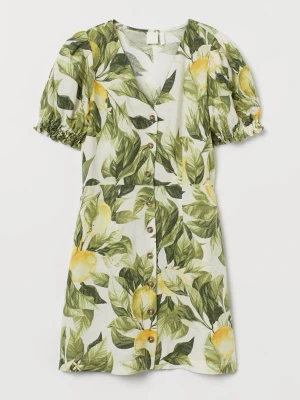 Kort citronmönstrad klänning H&M - Fräsch kort klänning från H&M med grönt och gult citronmönster på vit botten. Puffärmar med resår, v-ringning och knappar framtill. Perfekt för sommarens varma dagar, tillverkad i lätt och luftig bomull.
