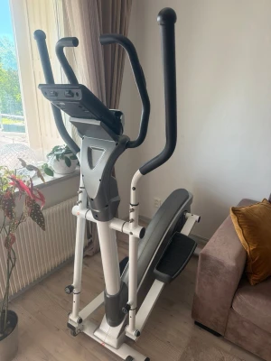 Crosstrainer svart och vit - Säljer en crosstrainer i svart och vitt med stora handtag och display framtill. Maskinen har robust ram i metall och plast, breda fotplattor och modern design. Perfekt för hemmaträning och kondition. Passar dig som vill träna smidigt hemma.