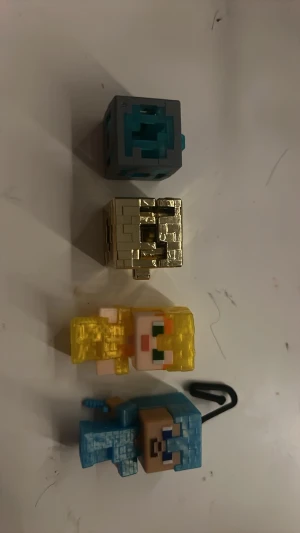 Minecraft minifigurer och block - Fyra små Minecraft-gubbar. Perfekta som samlarprylar eller dekoration till skrivbordet. Vet inte om dessa är värda något men ville se som en rolig grej. Den guldiga har jag hört och sett att den är en secret dock. Jag sätter Inget pris på detta eftersom jag inte vet vad det är värt. Det är splirrans nya och inte använda på något sätt. Så kontakta om det är något ni vill veta…