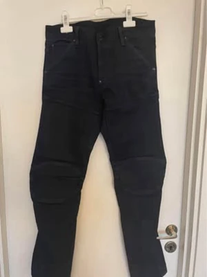 Jeans med raka ben - G-Star Raw 5620 3D Slim - Säljer ett par  jeans från G-Star Raw med raka ben och klassisk femficksmodell. Jeansen har förstärkta sömmar vid knäna och bälteshällor i midjan. Materialet är denim och färgen är djupsvart, perfekt till en streetwear-look.