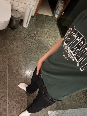 Grön Detroit t-shirt från Jack & Jones - Mörkgrön t-shirt från Jack & Jones med tryck i vitt och svart där det står 'Detroit Michigan Originals'. Klassisk passform och rund halsringning.  