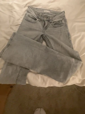 Ljusgrå raka jeans från Gina Tricot - Säljer ett par ljusgrå jeans från Gina Tricot med rak passform och klassisk femficksdesign. Jeansen har hög midja och är tillverkade i ett mjukt denimtyg som ger en avslappnad look. Perfekta till sneakers eller boots.