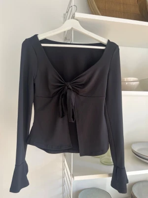 Svart långärmad blus med rosett  - Söt svart blus med rosett framtill. Aldrig använd och därav inga tecken på användning💕