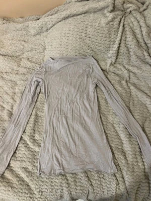 Ljusgrå långärmad topp - Slimmad och tunn långärmad topp i ljusgrått. Tröjan har enkel design med rund halsringning och är tillverkad i ett mjukt, stretchigt material som passar perfekt till lager-på-lager. Perfekt basplagg för alla tillfällen.