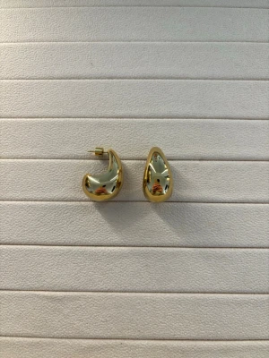 Guldiga droppformade örhängen - Superfina och simpla örhängen från Muli Collection. Dropformade och tillverkade i vattentåligt 18k guld PVD pläterad stål. Använda några gånger men i mycket fint skick.