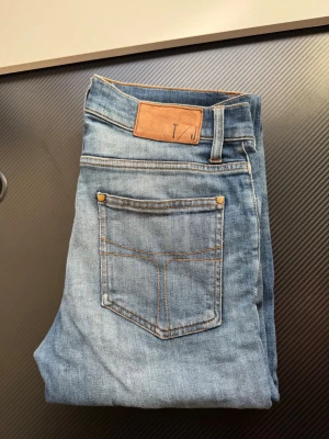 blå slitna jeans från TIGER OF SWEDEN - Mått syns på bilderna, skriv om ni vill ha fler bilder eller undrar över något. Priset är inte hugget 
