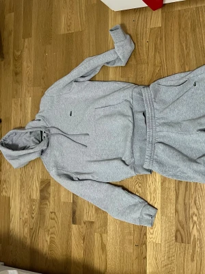 Gråa mjukisbyxor från Lacoste - Snygga gråa mjukisbyxor från Lacoste med klassisk krokodil-logga vid fickan.  den är ny inga problem med den inga skador eller något sånt tröjan är som xs och s skulle jag säga och byxan sitter samma som xs och s tar byten beror på vad och pris kan diskuteras köpt för cirka 2100 från zalando för ett tag sen 