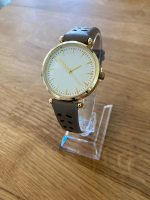 JG Gold Air 33mm Damur - Säljer en JG damklocka på 33mm med luftat läderarmband och gulddetaljer. Klockan är i mycket gott skick enligt bilder och har ett fungerande batteri.   Nypris: 500 SEK Begagnat värde: 250 SEK Mitt pris: 189 SEK  Skickas alltid snabbt och spårbart. Skriv vid frågor och se gärna mina andra annonser!   GRATIS: För betalande kunder erbjuder jag personlig experthjälp för dig att göra nya fynd (nytt & begagnat). Fråga för mer info!